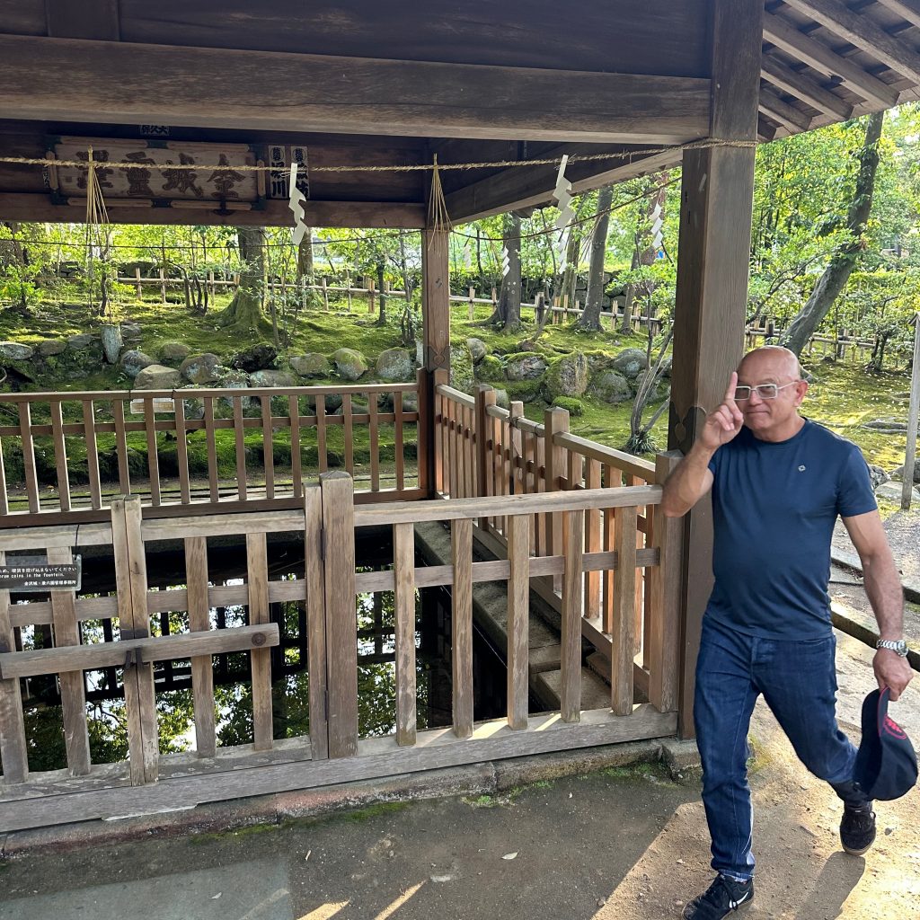 木造の建物の前を歩く男性