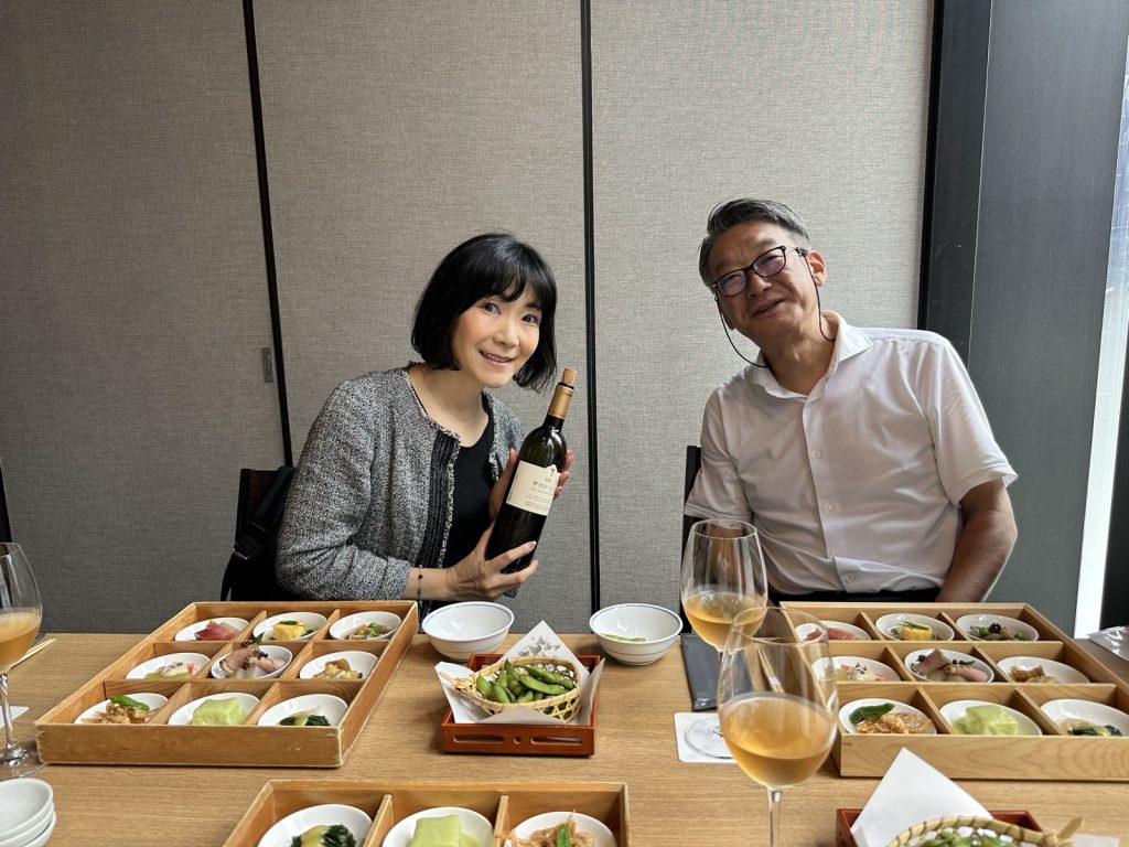 料理を前に、ワインボトルを手にする2人